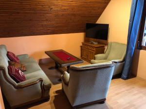 a living room with two chairs and a flat screen tv at Valentin Vendégház in Balatonlelle