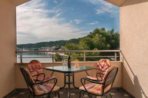 a balcony with a table and chairs and a view of the water at Apartmenthaus Kosirina-Tisno in Tisno