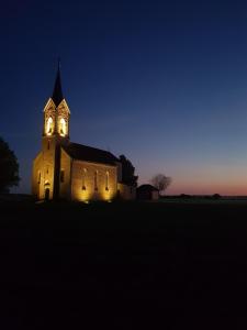 una iglesia con sus luces encendidas por la noche en Haus am Zabelstein, en Dingolshausen