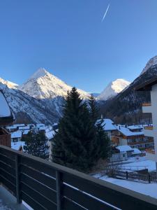 a view of a snowy mountain range from a balcony at Chalet Wanda in Saas-Fee