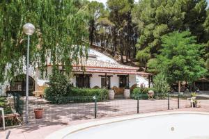 une maison avec une clôture devant elle dans l'établissement CASA CUEVA PIENA, Alcudia de Guadix, à Alcudia de Guadix