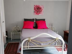 a bedroom with a bed with pink pillows at Gite la Tourbiere in Fellering +3 photos