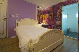 a bedroom with a white bed and a purple wall at 澎湖寶島時尚別館 Bao Dao B&B in Hui-min-erh-ts'un