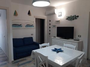 a living room with a white table and a blue couch at Appartamento Residence Mirice Vignola mare Aglientu casa Giorgia in Aglientu