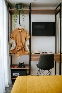 a bedroom with a desk with a jacket and a chair at Cosmo Napa Boutique Hotel in Ayia Napa