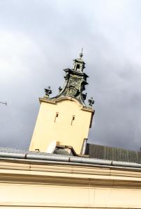 une tour d'horloge au sommet d'un bâtiment dans l'établissement Golden Rose ! Apartments Lviv, à Lviv