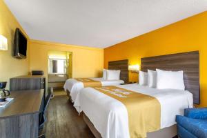 um quarto de hotel com duas camas e uma secretária em Days Inn by Wyndham Hampton Near Coliseum Convention Center em Hampton