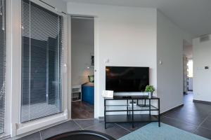Televízia a/alebo spoločenská miestnosť v ubytovaní Marina Apartman Hotel
