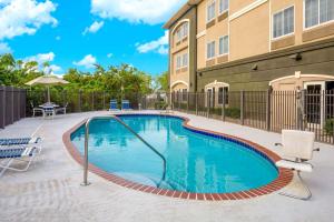 una piscina di fronte a un edificio di La Quinta by Wyndham Sebring a Sebring