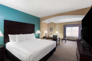 a hotel room with a large bed and a desk at La Quinta by Wyndham Sebring in Sebring