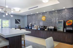 a restaurant with a counter and a bar with chairs at La Quinta by Wyndham Sebring in Sebring