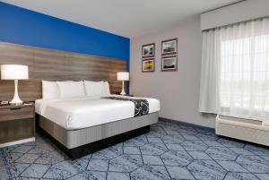a bedroom with a large bed and a blue wall at La Quinta by Wyndham Denton - University Drive in Denton