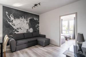 a living room with a couch and a wall mural at RentPlanet - Apartamenty Na Grobli in Wrocław