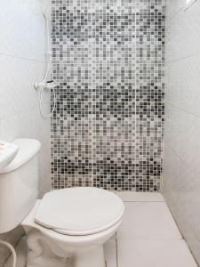 y baño con aseo y ducha de azulejos blancos y negros. en OYO Hotel Vintage, São Paulo, en São Paulo