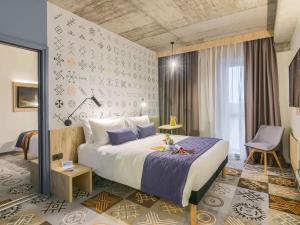 Un pat sau paturi într-o cameră la ibis Styles Bucharest City Center +37 fotografii