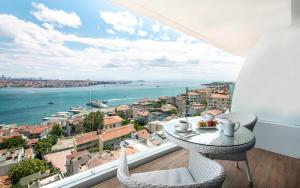 a balcony with a table and chairs and a view of the ocean at Opera Hotel Bosphorus in Istanbul