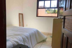 a bedroom with a bed and a window at Casinha de Campo bem localizada in Atibaia