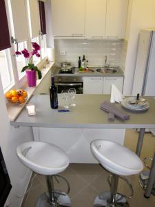 a kitchen with two bar stools and a counter top at Apartments Klementina in Postira