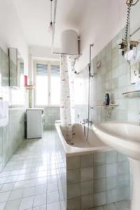 a white bathroom with two sinks and a tub at Chez Liviana in Rome