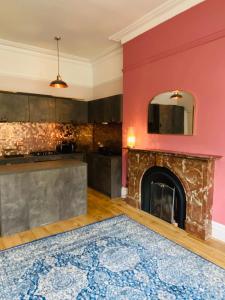 a living room with a fireplace and a red wall at Lovingly Restored Victorian Apartment in Hastings in Hastings