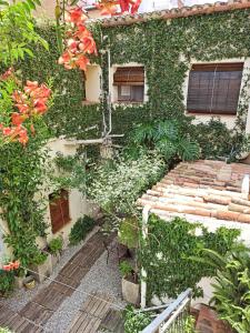 an ivy covered building with a walkway in front at Marakasa B&B in Sant Antoni de Calonge