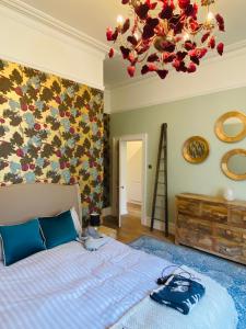 a bedroom with a bed and a chandelier at Lovingly Restored Victorian Apartment in Hastings in Hastings