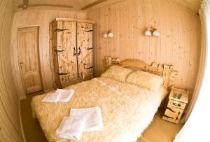 a bedroom with a large bed with two towels on it at Брусний View House in Sheshory