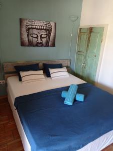 a blue and white bed with a blue blanket on top of it at Quinta Pereiro Tropic Garden, Algarve in Moncarapacho