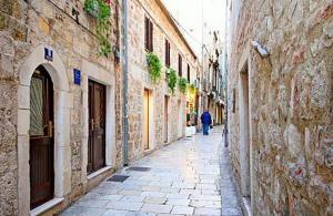 an alley with a person walking down a street at Duplex Studio Traversa- Split Old Town in Split