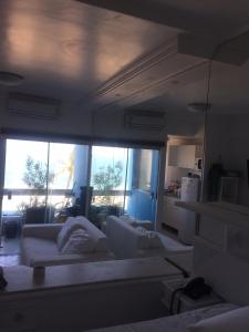 una sala de estar con 2 sofás blancos y una ventana grande en Bahia Flat Vista Mar 202, en Salvador
