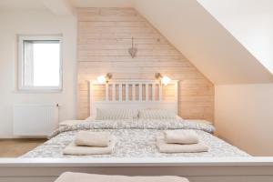 a white bedroom with a large bed with two pillows at Srdeční záležitost Boží Dar in Boží Dar