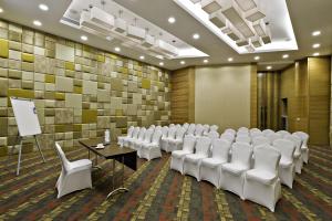 a conference room with white chairs and a podium at Meluha - The Fern in Mumbai