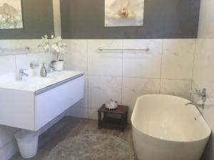 a white bathroom with a tub and a sink at C’est La Vie in Balgowan