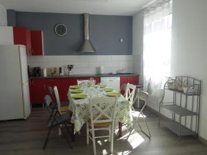 uma cozinha com uma mesa com cadeiras e um frigorífico em Home Bigarreaux em Le Mans