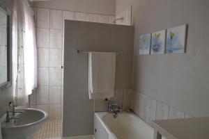 La salle de bains est pourvue d'une baignoire, d'un lavabo et d'une baignoire. dans l'établissement By The Way Guesthouse, à Clarens