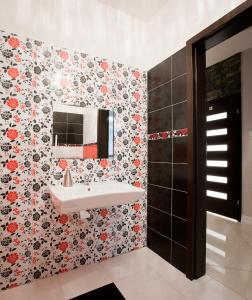 a bathroom with a sink and flowers on the wall at Hotel Arkadia in Ciechanowiec