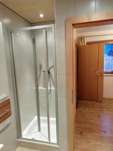 prysznic w łazience ze szklanymi drzwiami w obiekcie Haus Valentina w Alpbach