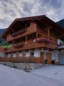 ein großes Holzhaus mit Blumen auf dem Balkon in der Unterkunft Haus Valentina in Alpbach