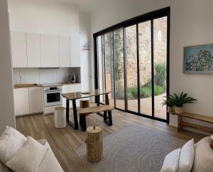 ein Wohnzimmer mit einem Tisch und einer Küche in der Unterkunft Lily l'Acrobate Aubagne-Cassis-Aix en Provence in Aubagne