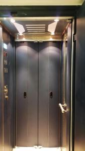 a row of metal elevator doors in a room at TINOS AQUA PALAZZO in Tinos Town