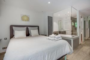 1 dormitorio con 1 cama blanca grande y toallas. en Wellholidays 19 - studio balnéo et terrasse piscine, en Boersch