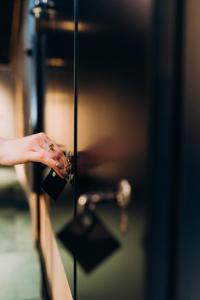 a woman is opening a door with her hand at Gruner Hotel in Lviv