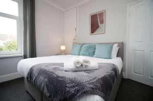 um quarto com uma cama com duas toalhas em No25 City House by SSW-close to City em Cardiff