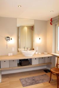 baño con lavabo y espejo grande en Herrliche Ferienwohnung in idyllischer Landschaft, en Morsum