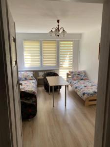 a room with two beds and a table and a couch at Stara Piekarnia - Apartament Dworcowa in Olsztyn