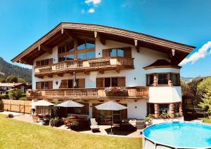 ein großes Haus mit Pool davor in der Unterkunft Apartment Hahnenkammblick in Reith bei Kitzbühel