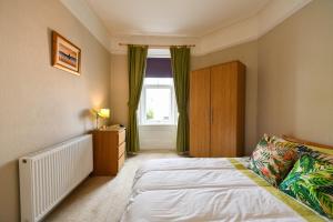 a bedroom with a bed and a window at Brae View Coastal Gem in Largs