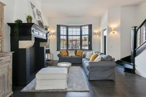 ein Wohnzimmer mit 2 Sofas und einem Kamin in der Unterkunft Maison Clos in De Panne