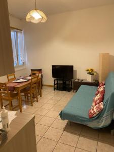 un soggiorno con divano, tavolo e TV di Appartamento Mosaico 22161 a Rovereto