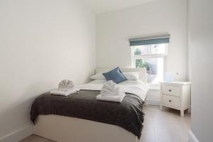 a white bedroom with a bed with towels on it at Lucas House in Newport